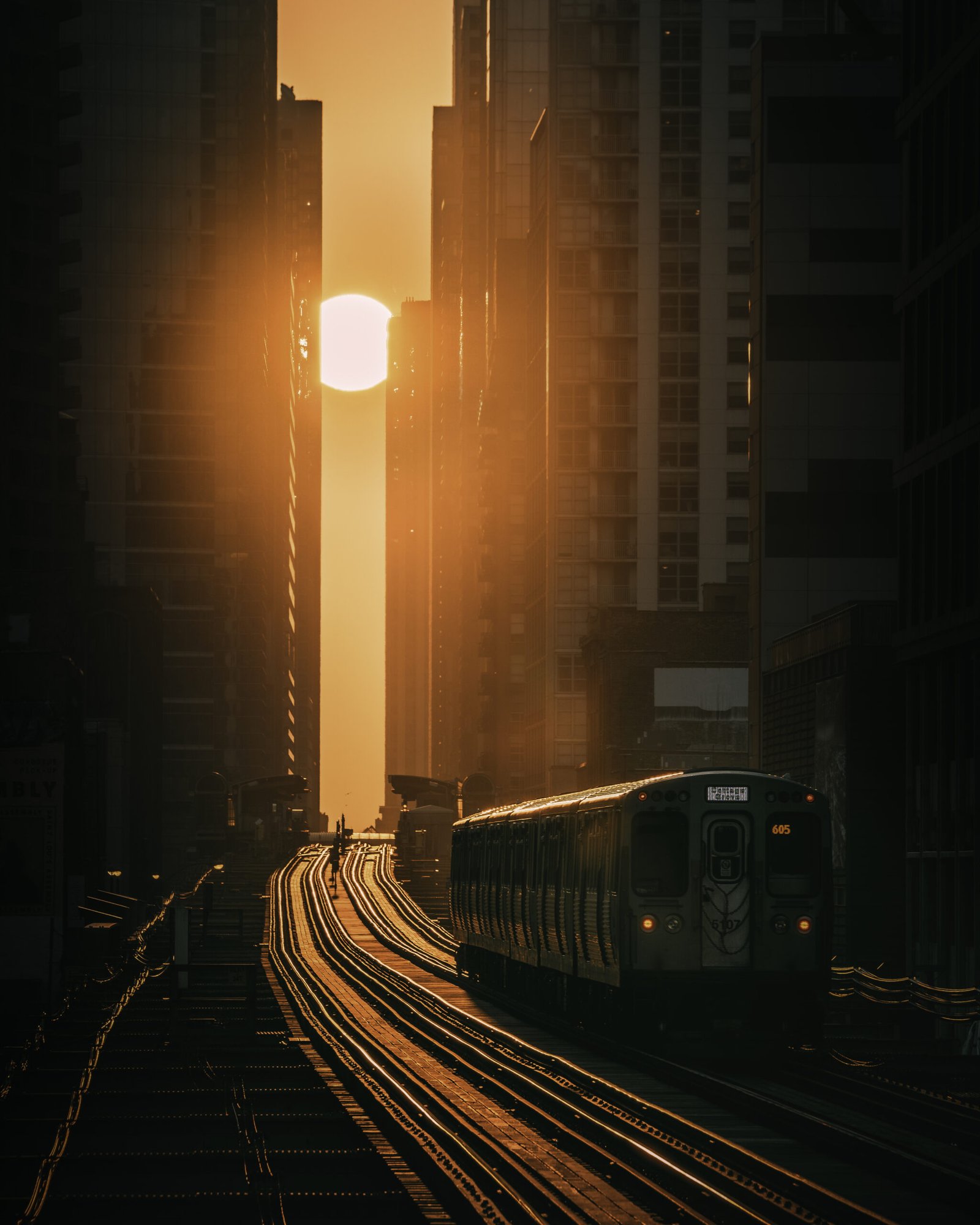 beautiful shot of a train speeding through the modern city towards the beautiful sunset